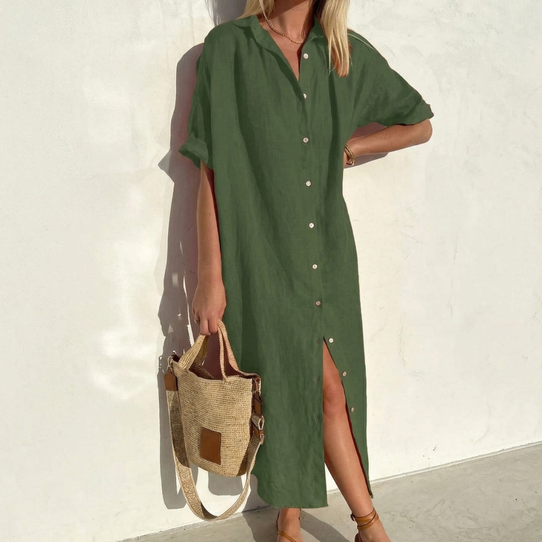 Abito camicia verde oliva con maniche corte e abbottonatura aperta sul fondo, indossato con sandali