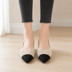 Vista frontale delle ballerine beige con puntale a contrasto nero e trama fitta
