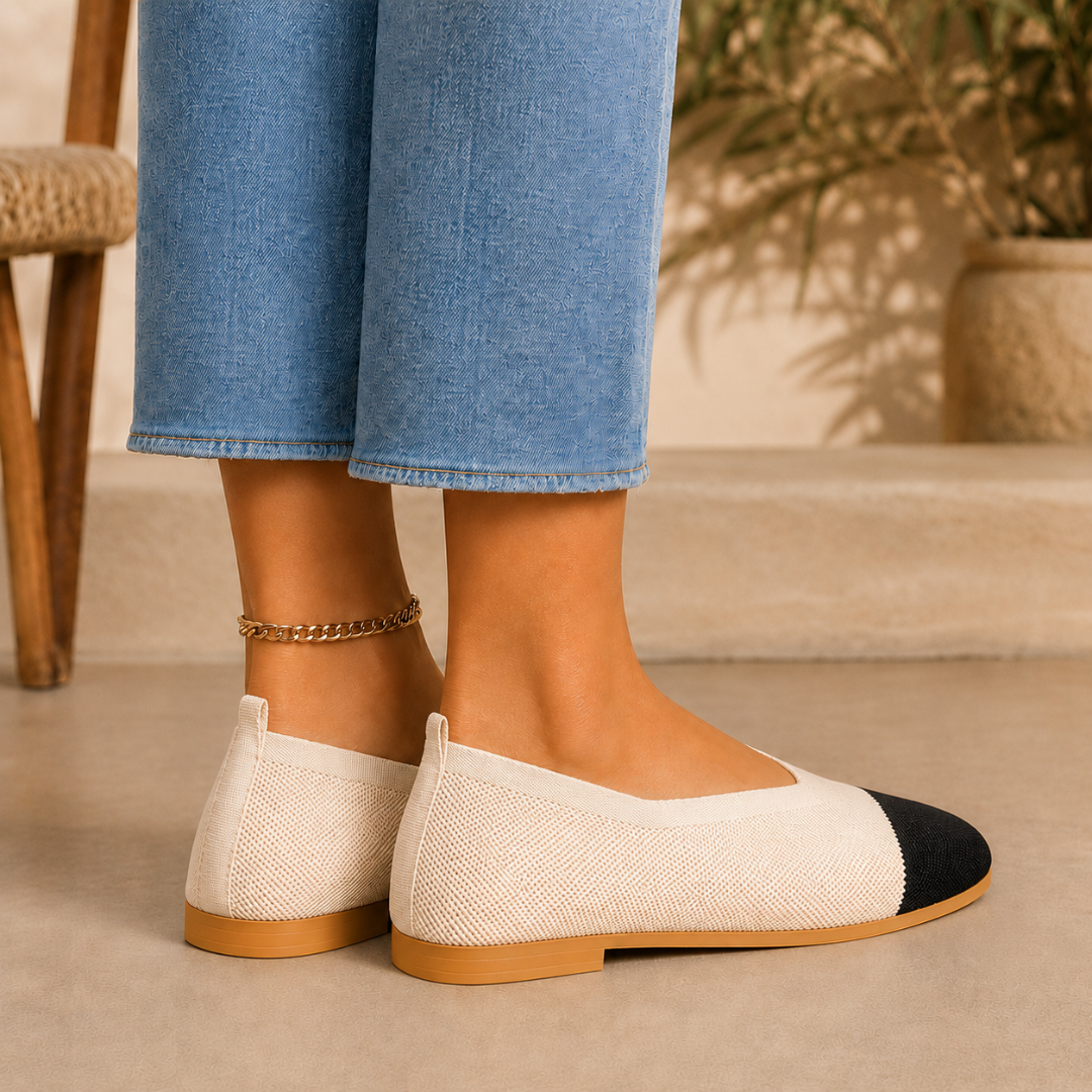 Vista laterale delle ballerine beige con tirante posteriore e punta nera