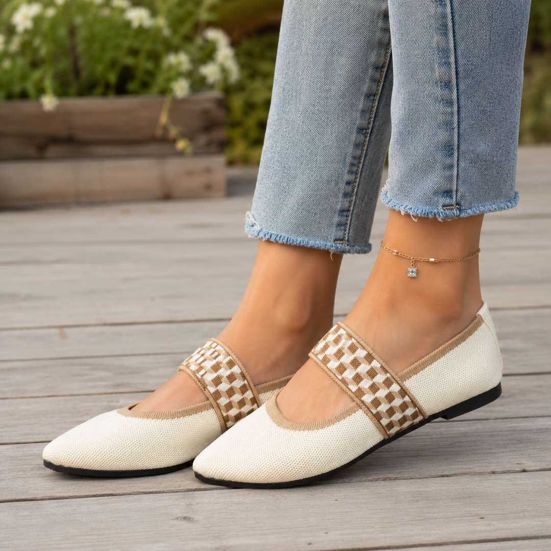 Ballerine beige indossate con pantaloni chiari, fascia elastica a scacchi sul collo del piede
