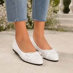 Ballerine donna bianche con fiocco sul davanti, riprese frontalmente su pavimento chiaro