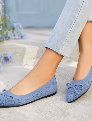 Ballerine blu chiaro traforate con fiocco, indossate con pantaloni chiari sfrangiati