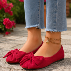Ballerine rosse con fiocco voluminoso davanti, abbinate a pantaloni chiari sfrangiati