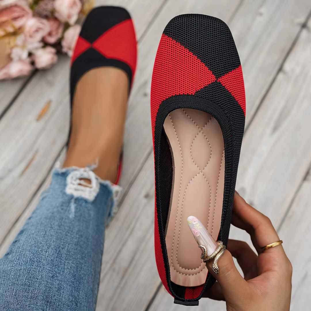 Ballerine donna rosse e nere tenute in mano, interno visibile e motivo bicolore sul davanti