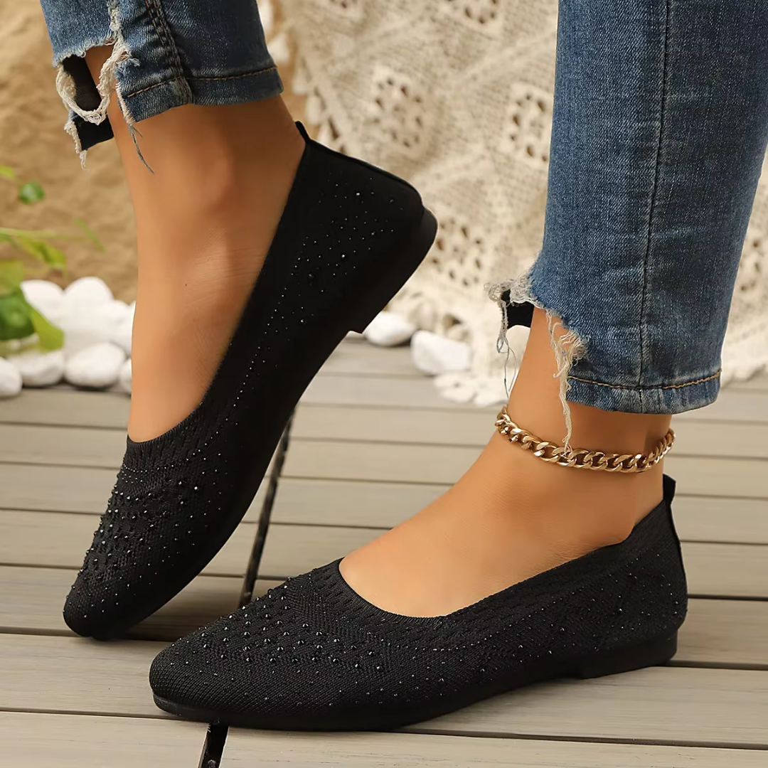 Ballerine nere slip-on con maglia traforata e suola sottile su terrazza