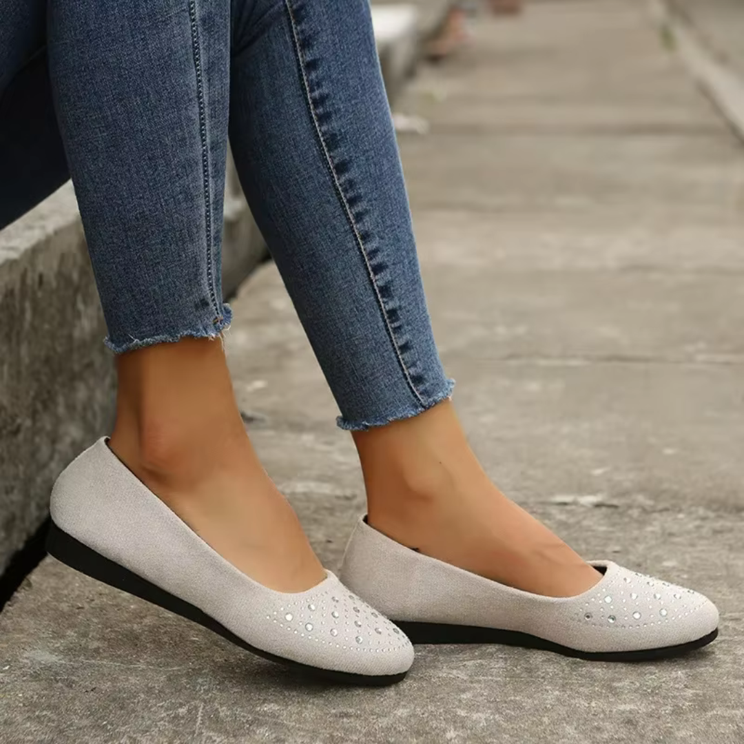 Ballerine bianco crema indossate con pantaloni skinny, suola piatta e scollatura arrotondata