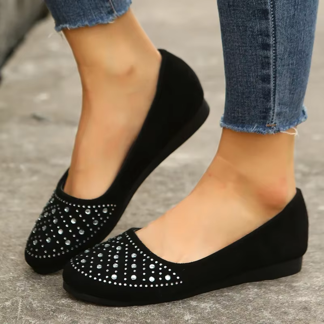 Ballerine nere indossate con pantaloni skinny, dettaglio strass sulla punta