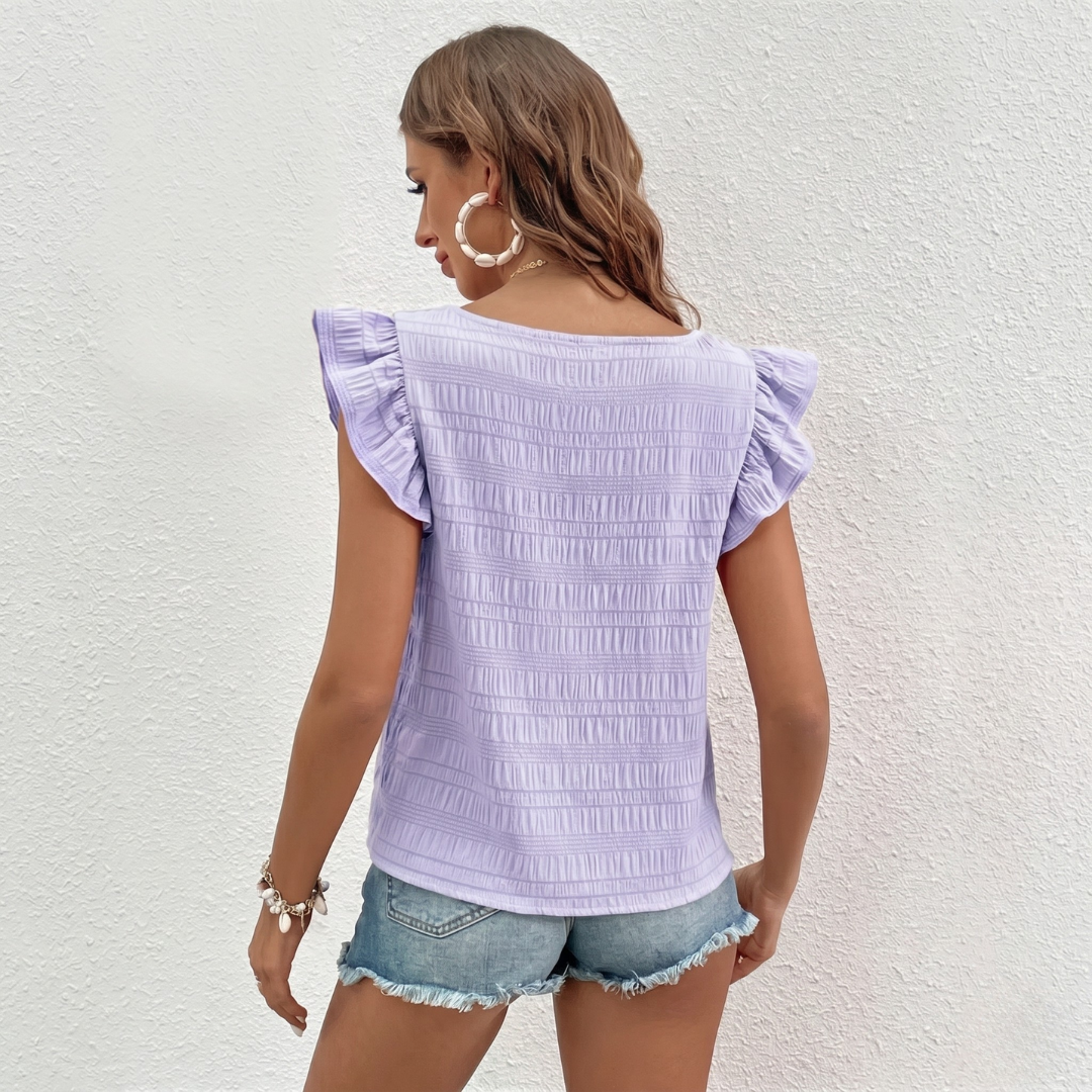 Retro della blusa lilla con superficie testurizzata a righe orizzontali e volant sulle spalle