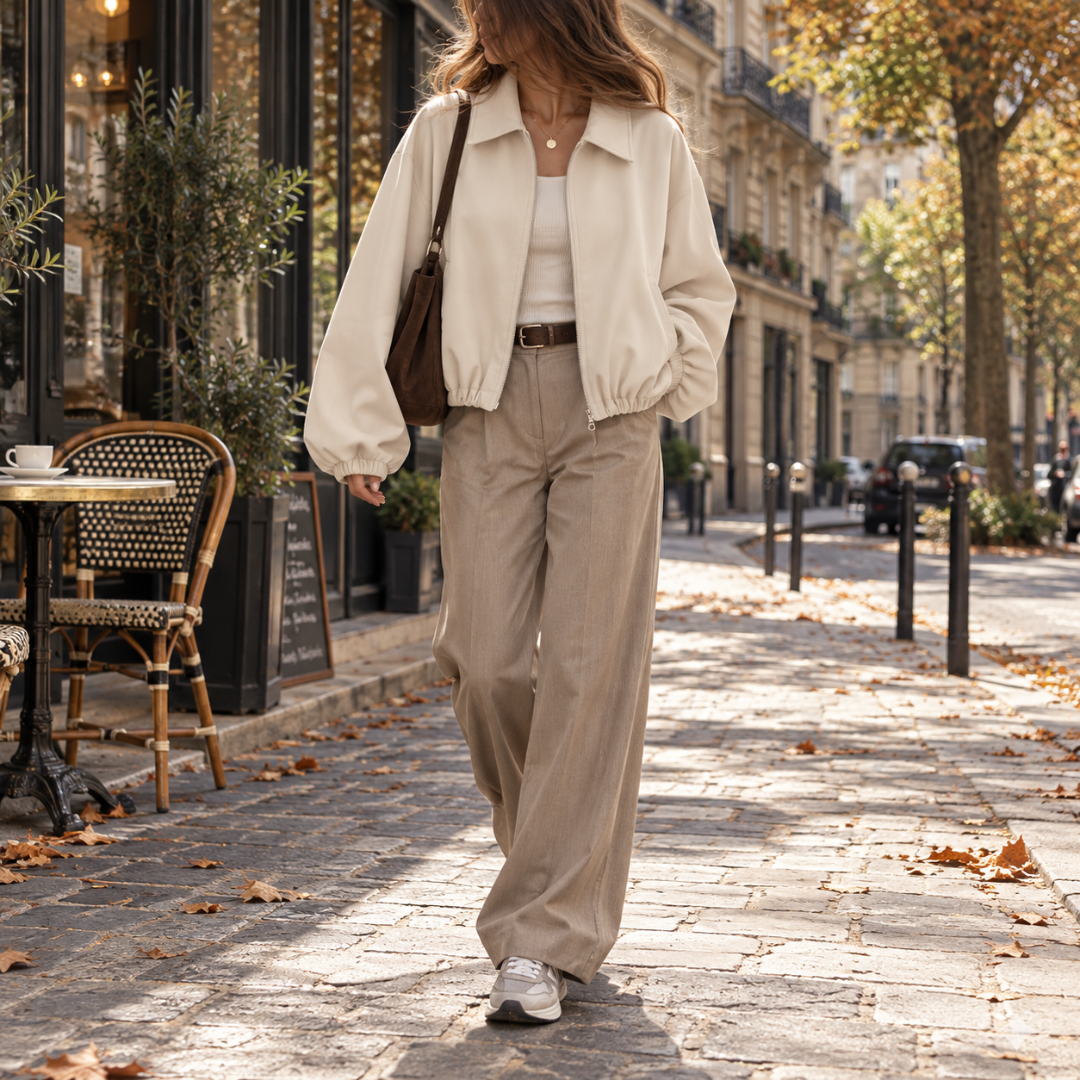 Bomber corto bianco con collo a camicia, zip aperta e pantaloni larghi beige