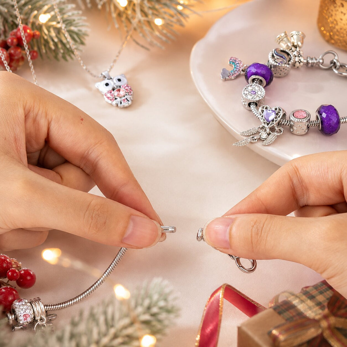 Mani compongono un braccialetto con charm, collana con gufo accanto