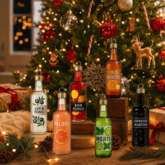 Sei pendenti bottiglia con motivi Mojito, Paloma e Old Fashioned davanti all'albero