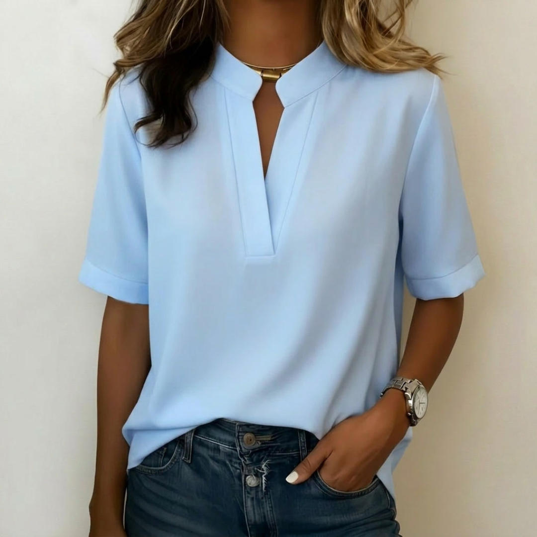 Camicetta donna azzurra con scollo a V e colletto alla coreana, portata sui pantaloni