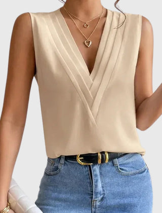 Camicetta beige smanicata con pieghe sulle spalle e scollo incrociato, look casual chic