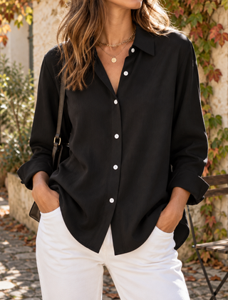 Camicia donna nera dalla linea fluida con colletto classico e bottoni chiari