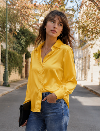 Camicia gialla lucida con colletto aperto e maniche lunghe su pantaloni blu