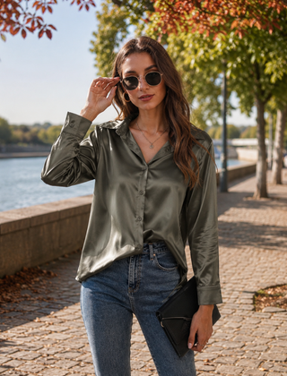 Camicia grigio scuro lucida con chiusura a bottoni, abbinata a pantaloni a vita alta
