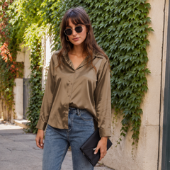 Camicia kaki scuro con bottoni sul davanti e spalle ampie su pantaloni chiari