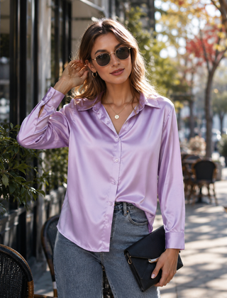 Camicia lilla con bottoni sul davanti e colletto a punta, portata sopra i pantaloni