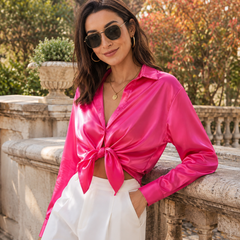 Camicia rosa fucsia intenso annodata in vita con pantaloni bianchi eleganti