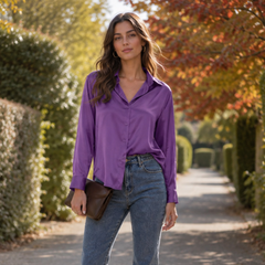Camicia viola lucida con colletto aperto, indossata con pantaloni e pochette marrone