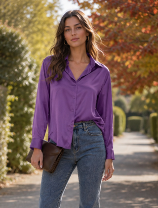 Camicia viola lucida con colletto aperto, indossata con pantaloni e pochette marrone