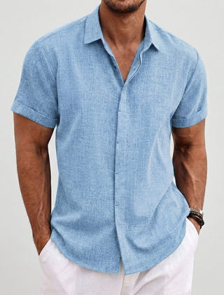 Camicia uomo azzurra maniche corte, look estivo con pantaloni bianchi e polsini risvoltati