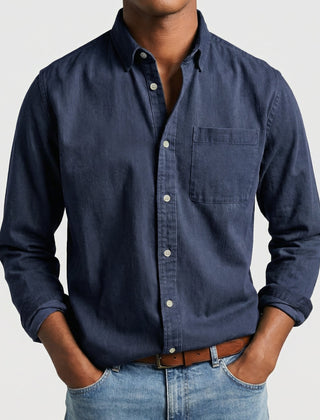 Camicia uomo blu navy con bottoni chiari e polsini arrotolati, look casual