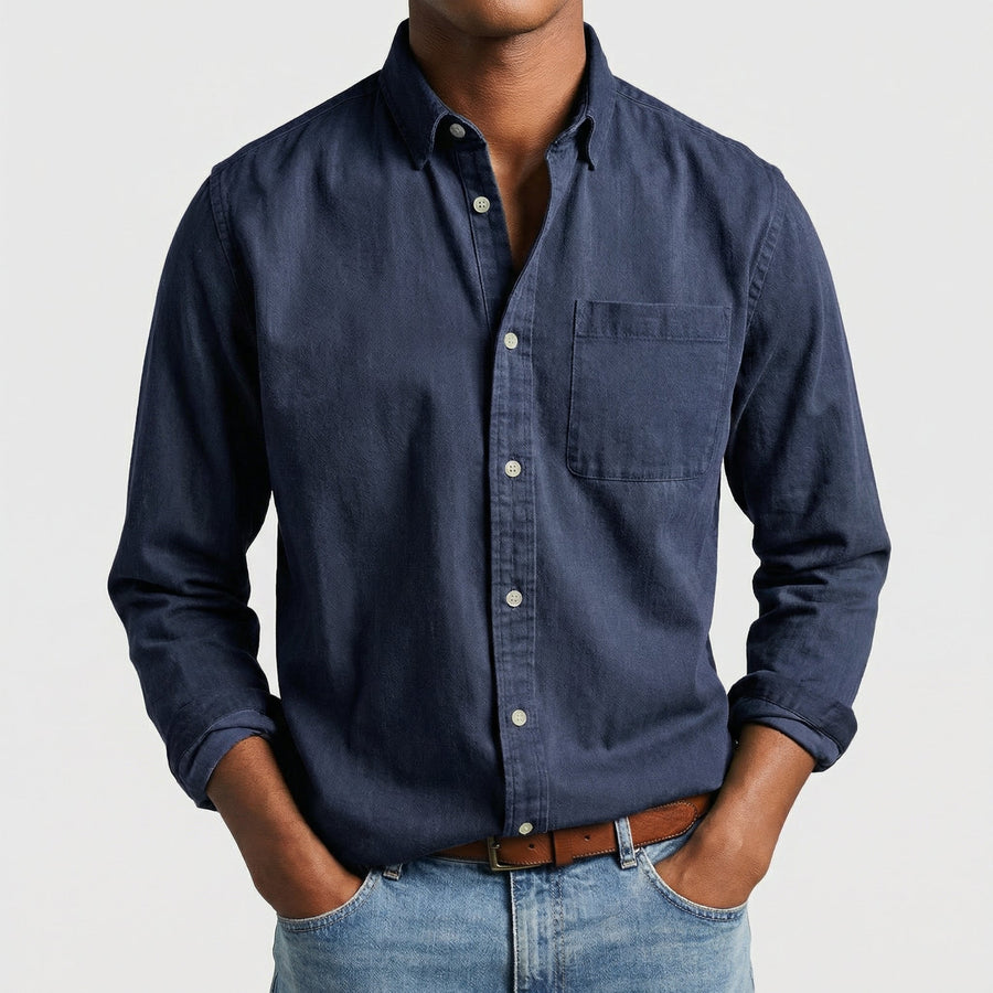 Camicia uomo blu navy con bottoni chiari e polsini arrotolati, look casual