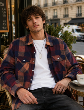 Camicia uomo a quadri marrone multicolore indossata aperta su t-shirt bianca, taschini con patta