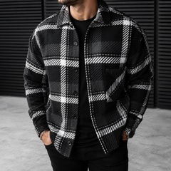 Camicia uomo nera a quadri bianchi indossata aperta su maglia nera
