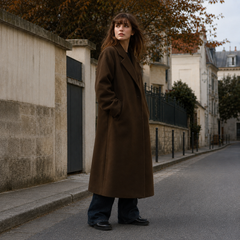 Vista laterale del cappotto marrone lungo con tasche laterali e collo a revers