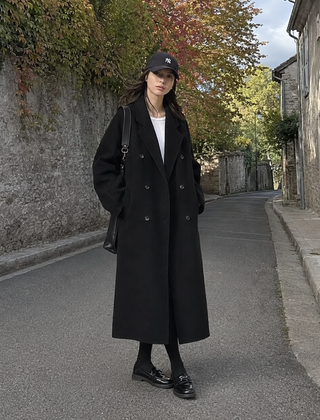Cappotto lungo nero a doppiopetto con collo a revers e spalle ampie