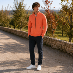 Uomo indossa cardigan arancione con zip chiusa e pantaloni blu scuro