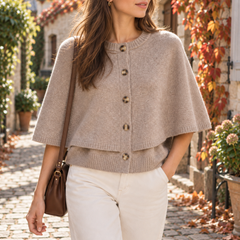 Cardigan beige in maglia con mantellina sovrapposta e bottoni, indossato con pantaloni bianchi