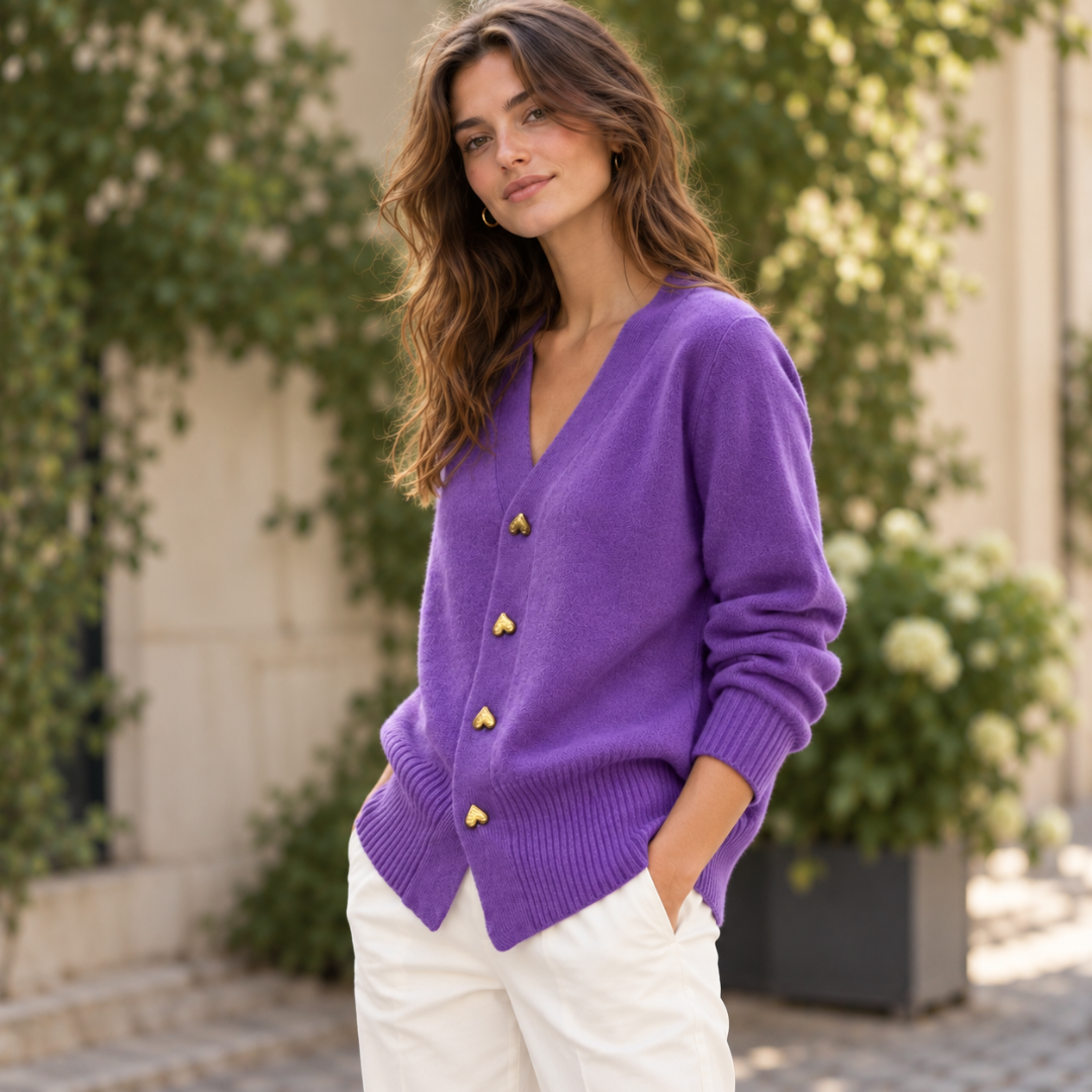 Donna in cardigan viola abbottonato con quattro cuori dorati e pantaloni bianchi