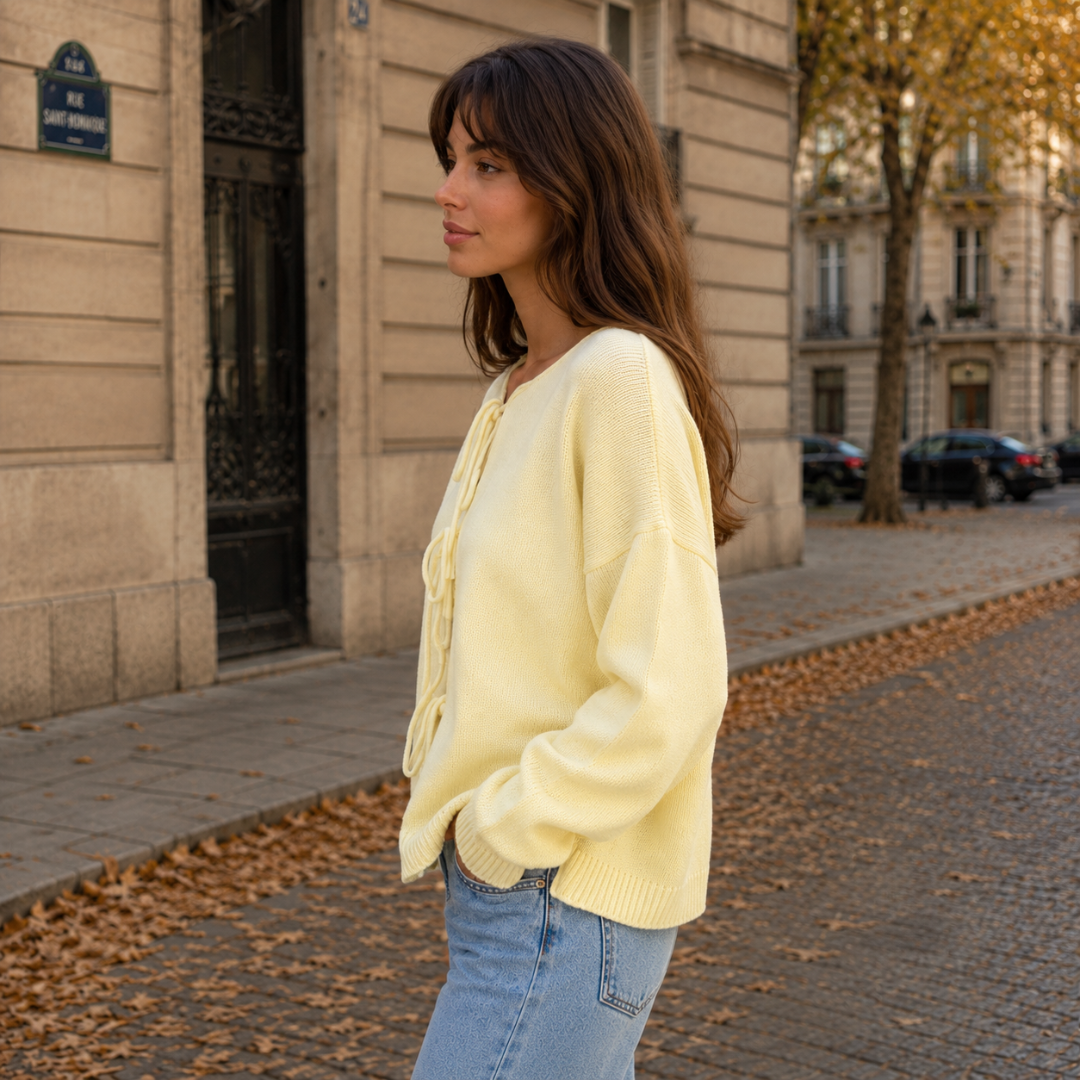 Vista laterale del cardigan giallo con spalle scese e polsini a coste