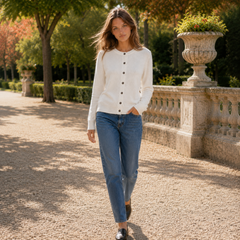 Cardigan bianco abbottonato indossato con pantaloni dritti blu e mocassini neri