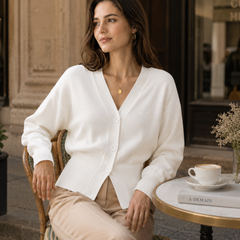 Donna seduta al caffè con cardigan bianco a scollo a V e bottoni