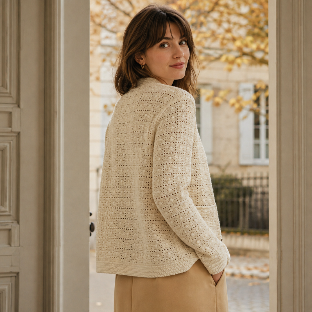 Cardigan beige di spalle, maglia traforata e bordo inferiore lavorato