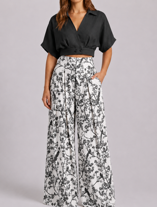 Completo donna nero con crop top e pantaloni palazzo bianchi a stampa floreale