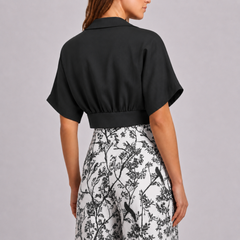 Schiena del completo nero con pantaloni bianchi stampati a rami e uccellini