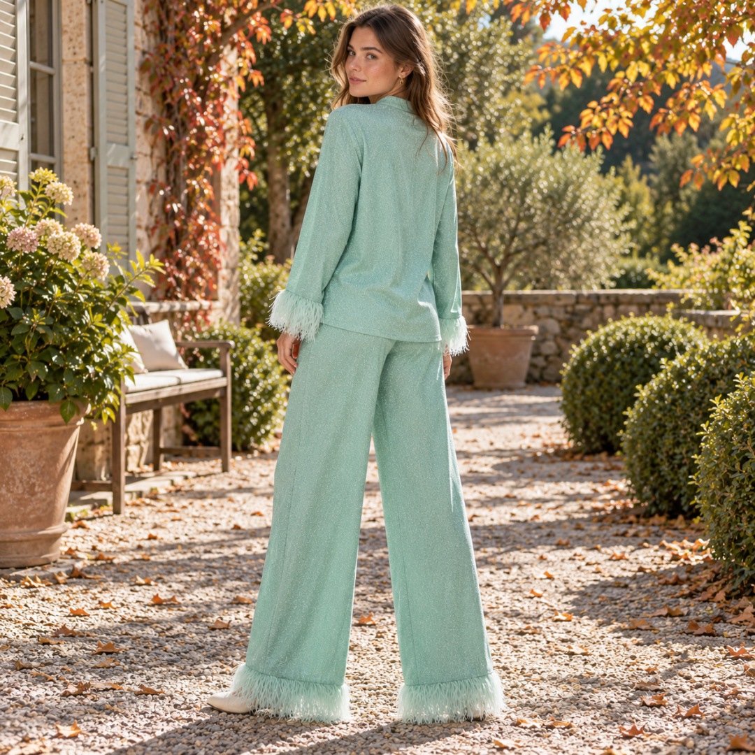 Retro del completo donna verde con orli dei pantaloni rifiniti in piume