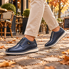 Derby uomo blu con stringatura e suola bianca indossate su pavé