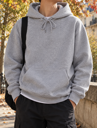 Felpa grigio chiaro con cappuccio e tasca frontale, indossata con pantaloni neri