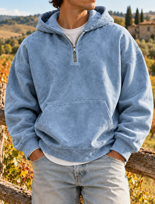 Felpa blu con cappuccio e mezza zip indossata con pantaloni chiari