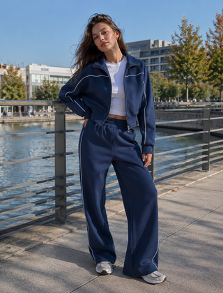 Felpa con zip blu da donna dalla linea corta con profili bianchi a contrasto