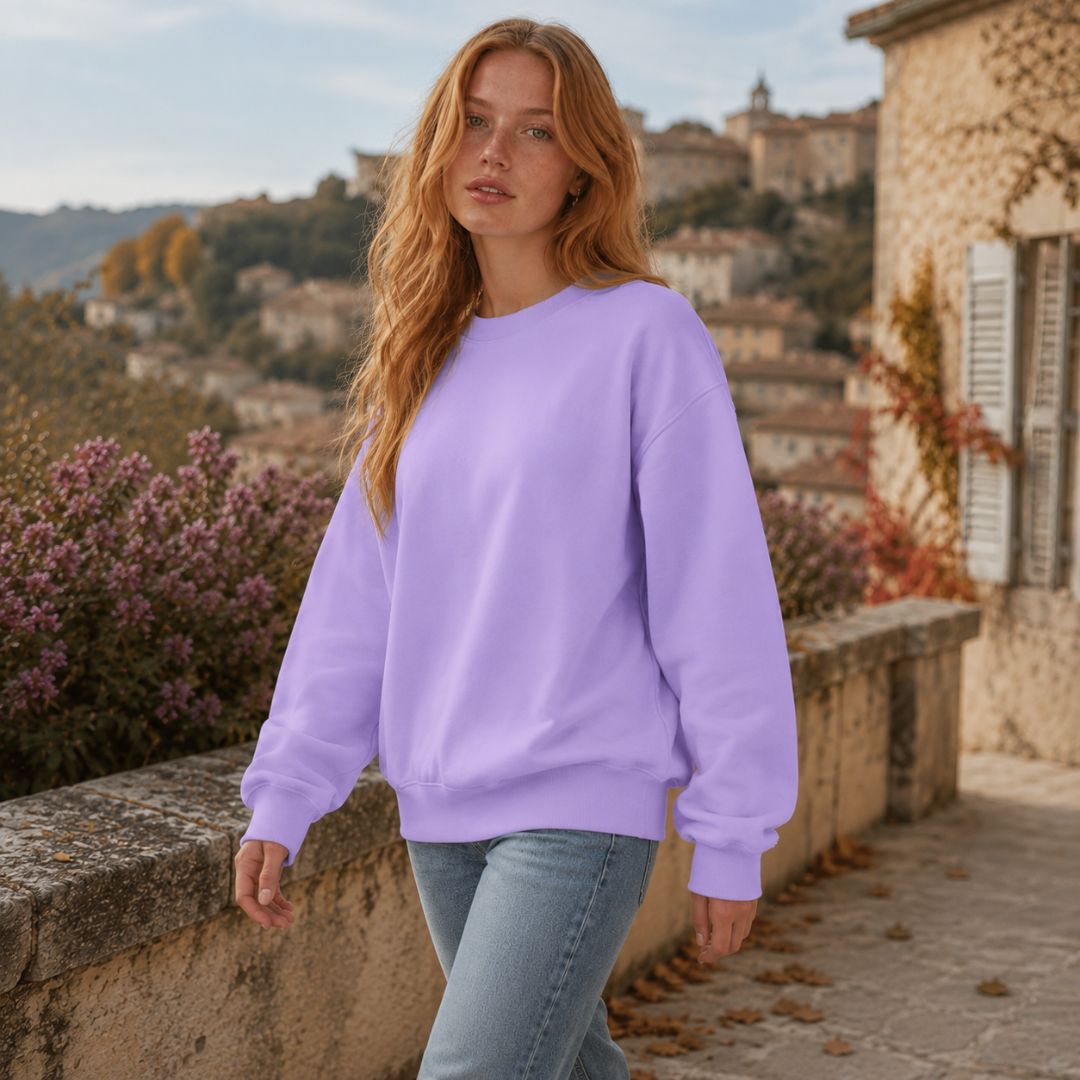 Felpa viola girocollo indossata con pantaloni chiari, maniche lunghe ampie