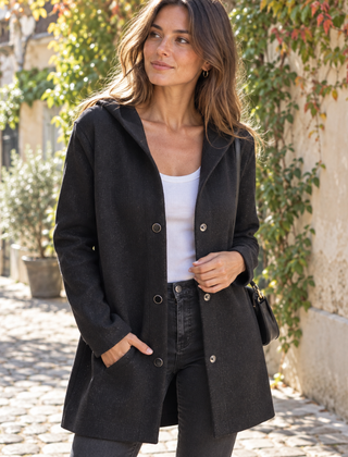 Giacca nera con cappuccio, bottoni metallici e tasche laterali, look urbano autunnale