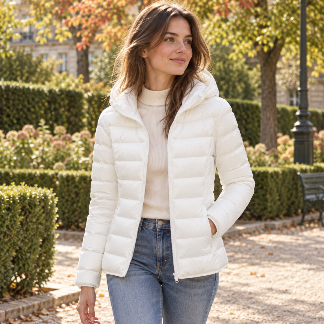 Giacca trapuntata bianca con cappuccio aperta su maglione chiaro, vista frontale