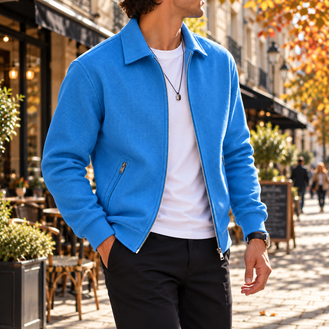 Uomo cammina con giacca blu aperta, colletto a camicia e fondo a costine